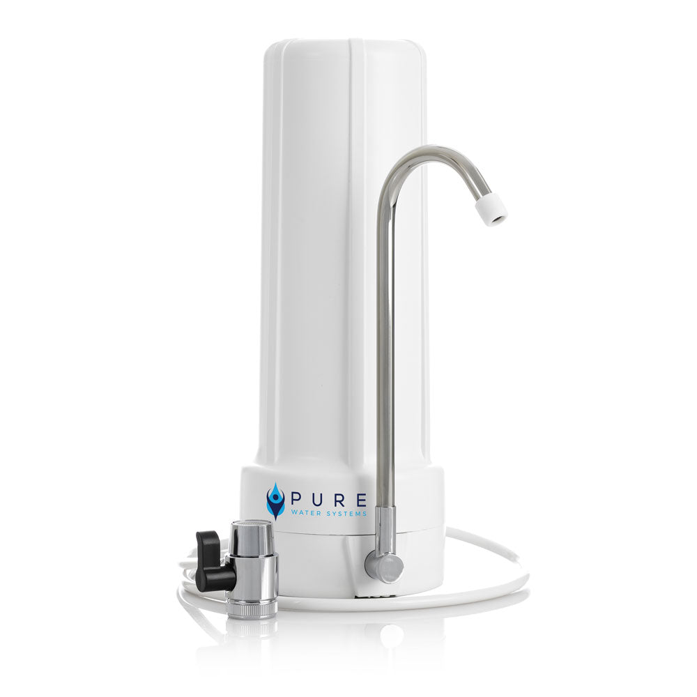 White slimline bench top water filter with chrome curved faucet and black valve attachment.